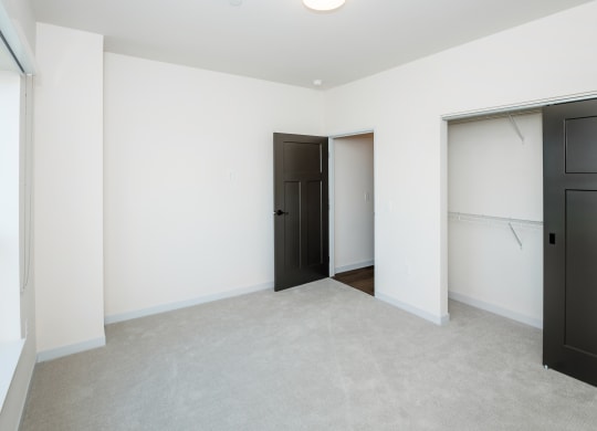 a bedroom with white walls and black doors and a closet at The Crossings  at Windsong, Arizona, 86314