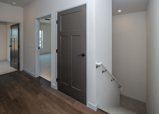 a door is open to a hallway with a staircase and a door to a bedroom at The Crossings  at Windsong, Prescott Valley, AZ