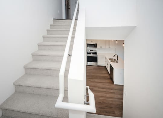 a staircase with white railings leading up to a kitchen in a house at The Crossings  at Windsong, Prescott Valley, Arizona