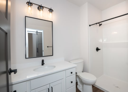 a bathroom with a white sink and toilet and a shower at The Crossings  at Windsong, Prescott Valley, 86314