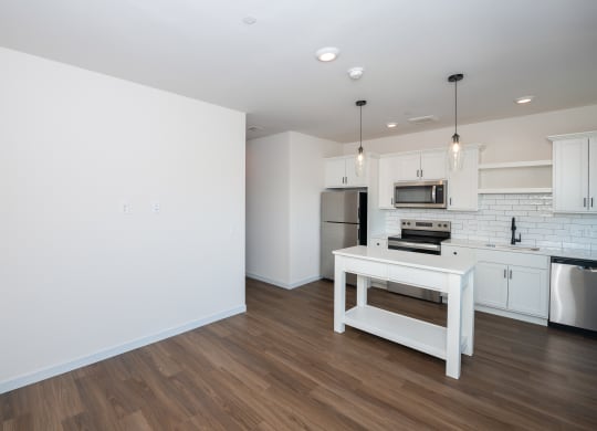 a white kitchen with a white island and a stainless steel refrigerator at The Crossings  at Windsong, Prescott Valley, AZ