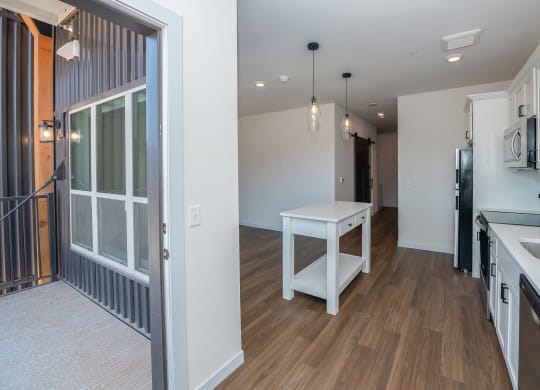 a renovated kitchen and living room with a large window and a white table at The Crossings  at Windsong, Prescott Valley, Arizona