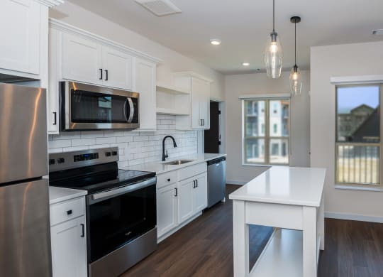 a kitchen with white cabinets and stainless steel appliances at The Crossings  at Windsong, Prescott Valley, AZ
