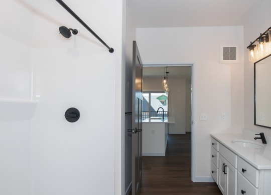 a bathroom with a sink and a shower and a hallway with a door at The Crossings  at Windsong, Arizona, 86314