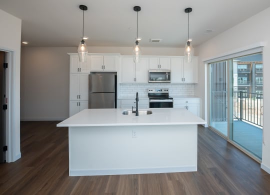 a white kitchen with a large island and stainless steel appliances at The Crossings  at Windsong, Prescott Valley, Arizona