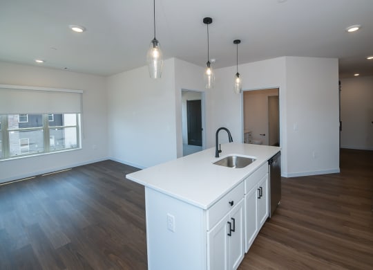 a kitchen and living room with white cabinets and a white counter top at The Crossings  at Windsong, Arizona, 86314