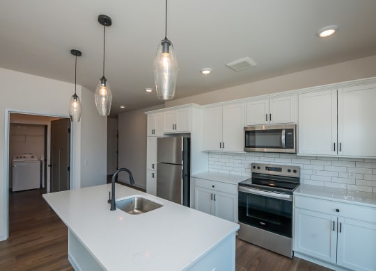 a kitchen with white cabinets and stainless steel appliances at The Crossings  at Windsong, Prescott Valley, Arizona