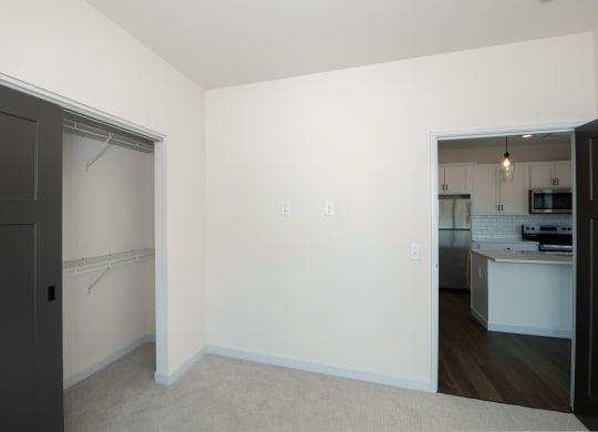 a bedroom with a door to a kitchen and a living room at The Crossings  at Windsong, Arizona