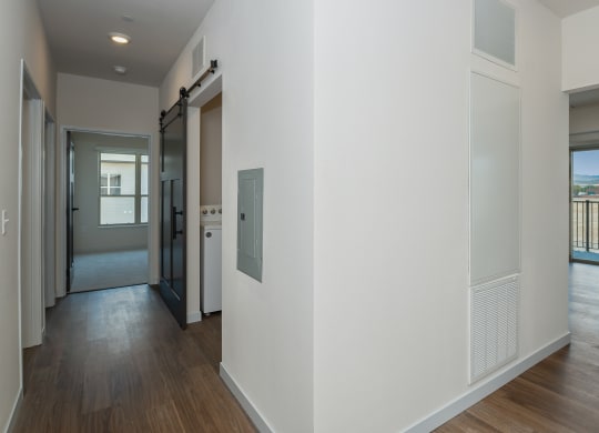 a hallway with white walls and wood flooring and a door to a balcony at The Crossings  at Windsong, Prescott Valley, AZ