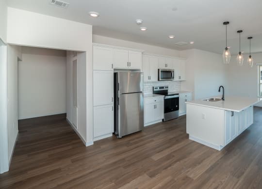 a kitchen with white cabinets and a stainless steel refrigerator at The Crossings  at Windsong, Arizona