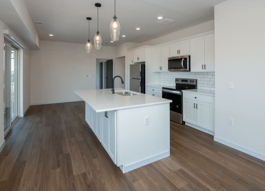 a large white kitchen with a large island in the middle at The Crossings  at Windsong, Arizona