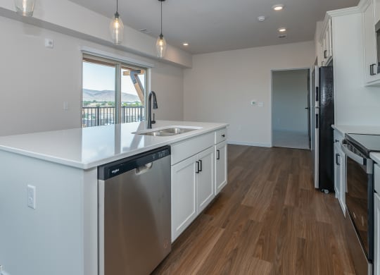 an open kitchen with a large island and a stainless steel dishwasher at The Crossings  at Windsong, Prescott Valley, AZ