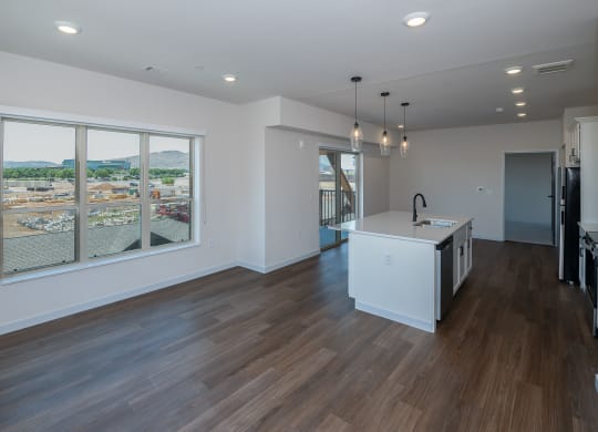 a living room with a large window and a kitchen with a island at The Crossings  at Windsong, Prescott Valley