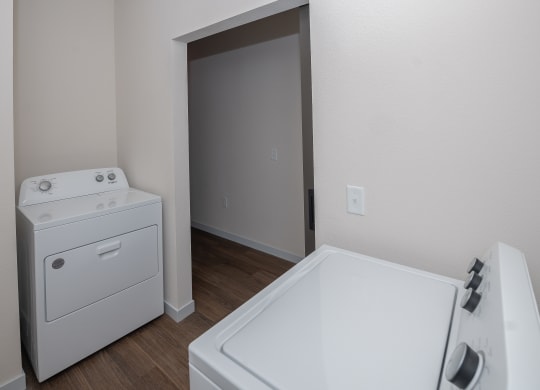 a white washer and dryer in a room with a door to a bathroom at The Crossings  at Windsong, Arizona