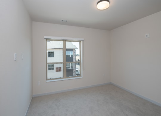 a bedroom with a large window and white walls at The Crossings  at Windsong, Prescott Valley