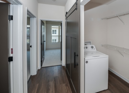 a walk in shower with a wood floor and a white washer and dryer at The Crossings  at Windsong, Prescott Valley, Arizona