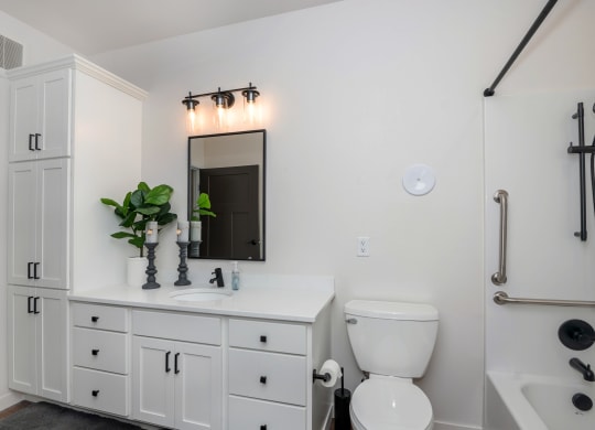 a bathroom with white cabinets and a white toilet and sink at The Crossings  at Windsong, Prescott Valley, AZ