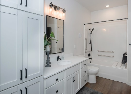 a bathroom with white cabinets and a white toilet and a sink and a bath tub at The Crossings  at Windsong, Arizona
