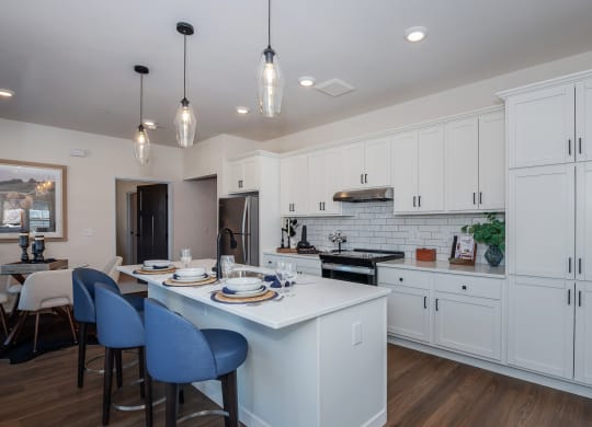 an open kitchen and dining room with white cabinets and a white counter top at The Crossings  at Windsong, Prescott Valley, AZ