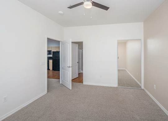 A room with a ceiling fan and carpeted floor.