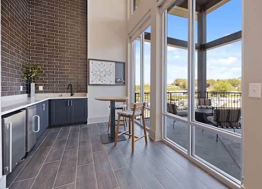 A kitchen with a table and chairs in front of a window.
