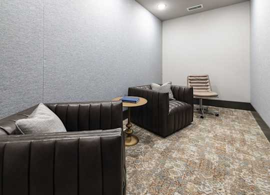 A living room with a brown leather couch and a patterned carpet.