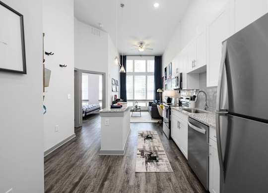 A modern kitchen with stainless steel appliances and wooden floors.