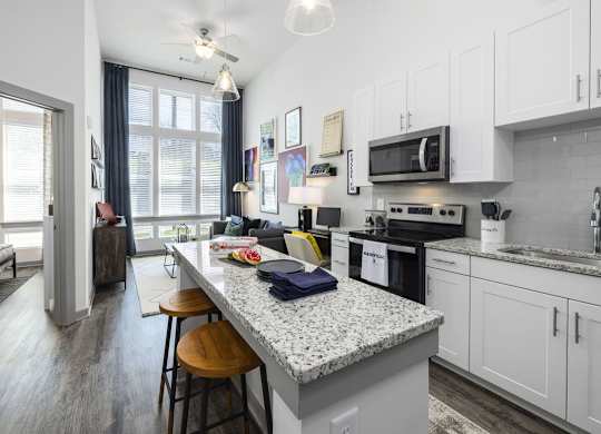 A kitchen with a granite countertop and white cabinets.