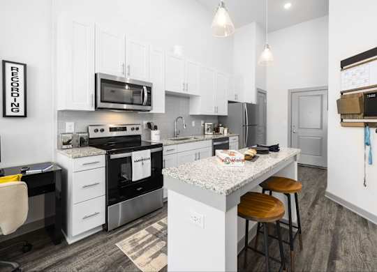 A modern kitchen with a white island and stainless steel appliances.