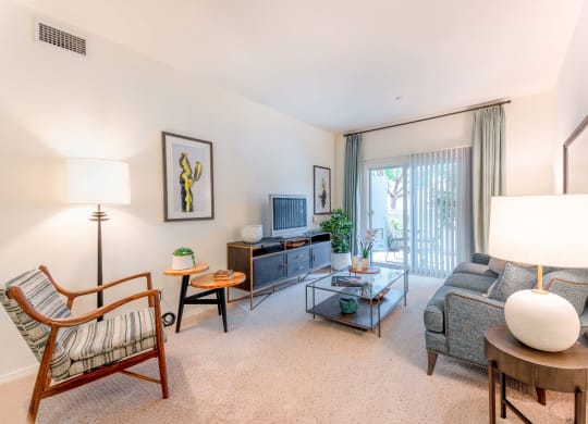 Goleta, CA Apartments-Sumida Gardens-Living Room with Carpet Flooring, High Ceilings, and Glass Sliding Door to Patio