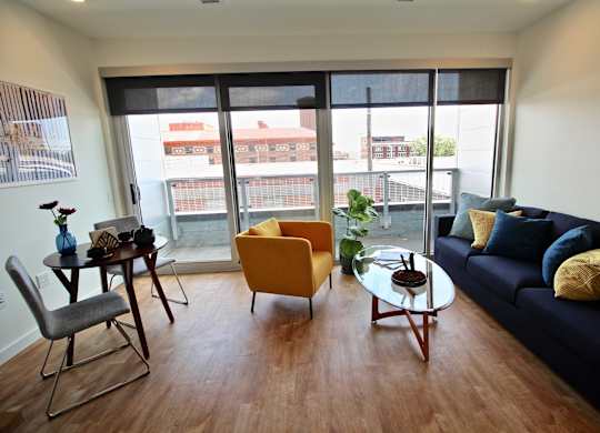 A living room with a blue couch and a yellow chair.
