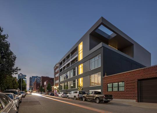 A modern building with a parking lot in front of it.