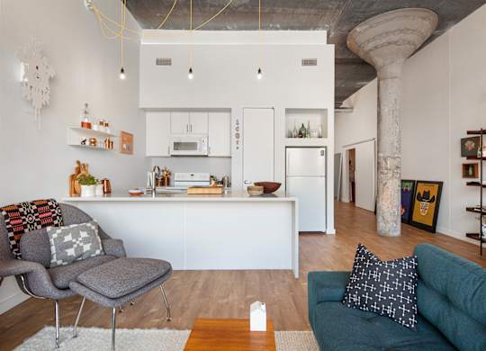 A modern kitchen with white cabinets and a wooden floor.
