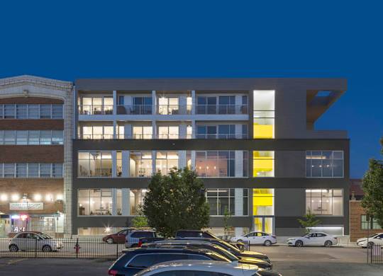 A modern building with a parking lot in front of it.