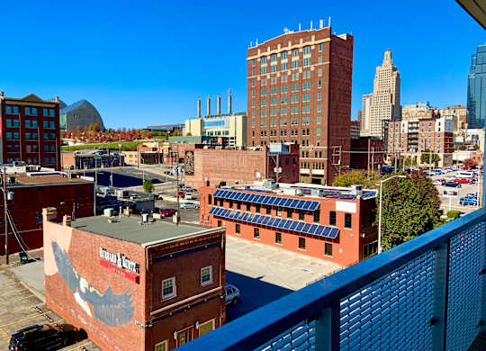 A cityscape with a building that has a mural of a bird on it.