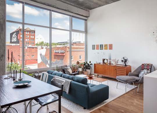A living room with a view of the city through large windows.
