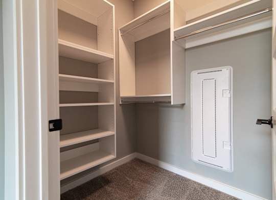 A white pantry with a white door and shelves.