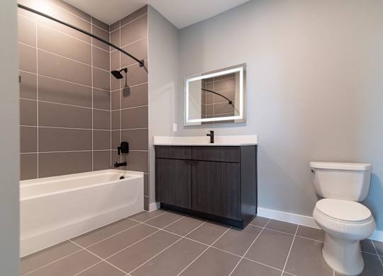 A bathroom with a white toilet and a white bathtub.