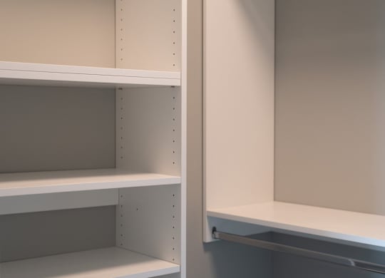 Empty white shelves with holes for hanging items.