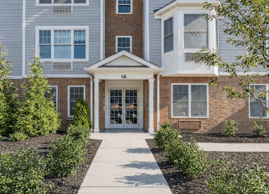 A building with a front entrance and a walkway leading to it.