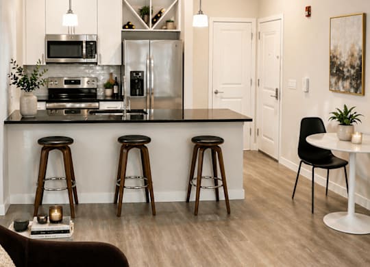 A modern kitchen with a bar area and a dining table.