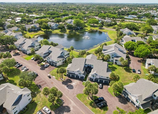 an aerial view of a neighborhood with houses and a lake at The Villages Apartment of Banyan Grove Apartments for rent in Boynton Beach FL