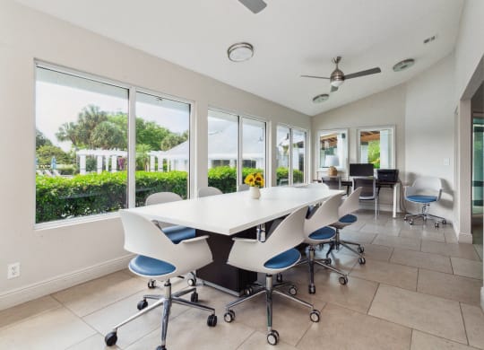 a conference room with a white table and chairs and windows at The Villages of Banyan Grove, Boynton Beach, 33436