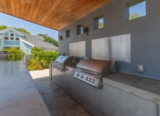 an outdoor kitchen with a grill and a wooden ceiling at The Villages of Banyan Grove, Boynton Beach, FL, 33436