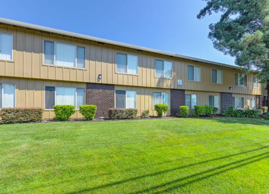 Asbury Place Apartment buildings with green grass outside and large trees
