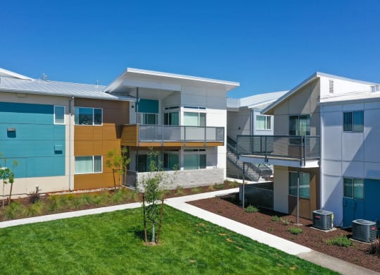 Apartment Exterior with Walking Path, Grass, Wood Chip Floor, Blue Apartment Exterior at Addison Ranch Apartments, Petaluma, California