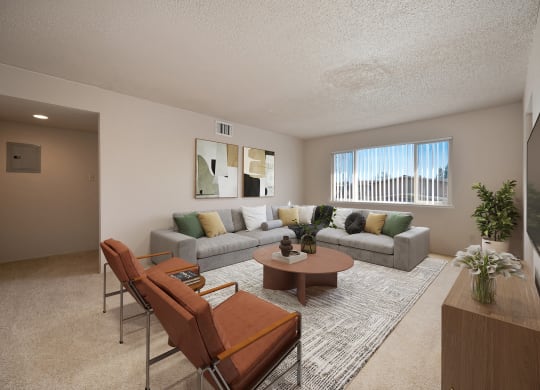 the living room of an apartment with a couch and chairs