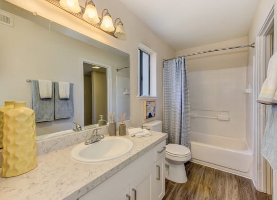 Bathroom with Quartz Counters, Hardwood Inspired Floor, Toilet and Vanity at Silverstone Apartments, California, 95618