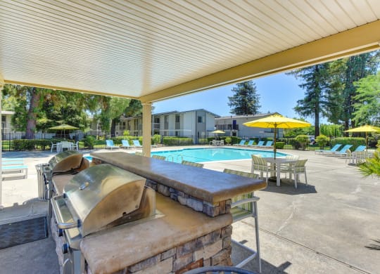 BBQ Area at Pool with Chairs, Tables and Patio Umbrellas at Renaissance Park Apartments, California, 95618