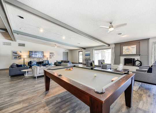 Clubhouse Sitting Area with Pool Table, Hardwood Inspired Floor, Gray and White Sofas at The Renaissance Apartments, Citrus Heights, CA